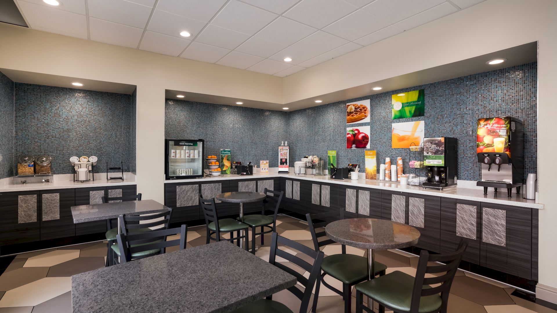 A brightly lit self-serve breakfast area in a hotel with a variety of food and drink options, including a cereal dispenser, coffee maker, and juice machine.